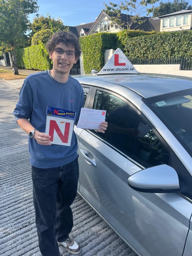 Learner driver celebrating a driving test pass with Dundrum School of Motoring