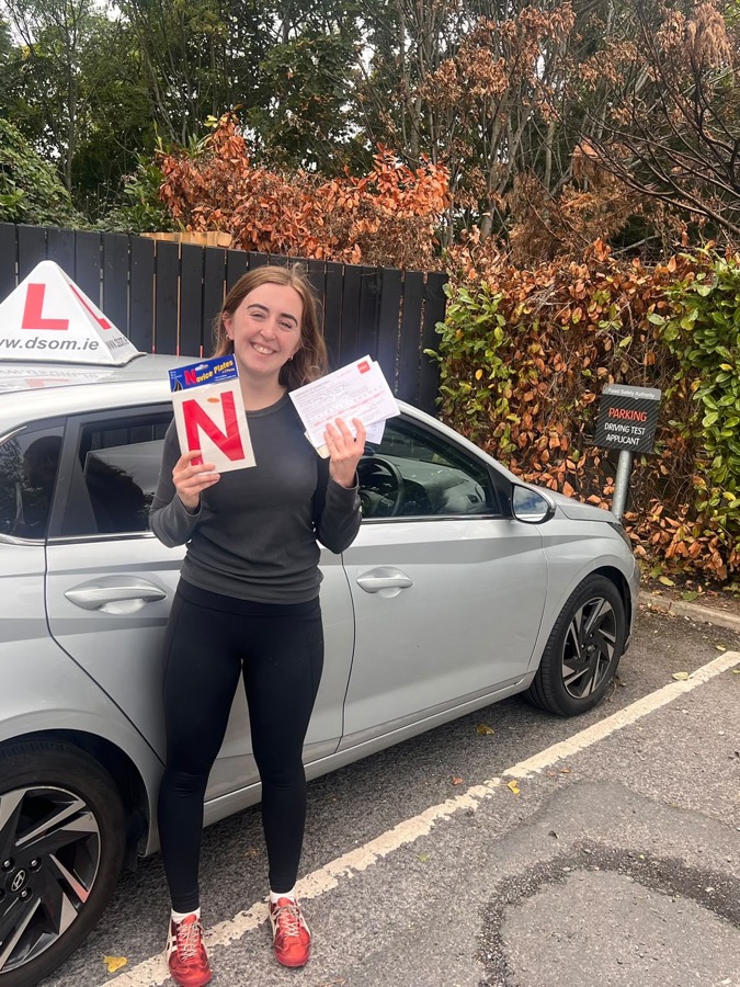 Learner driver celebrating a driving test pass with Dundrum School of Motoring